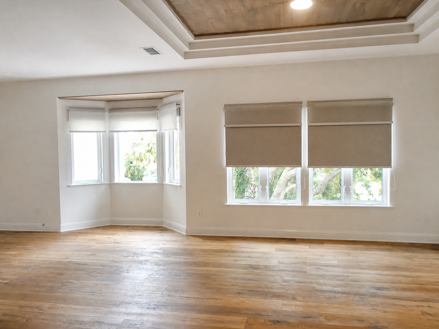 Custom roller shades installed across bay and rectangular windows in a Ponte Vedra home