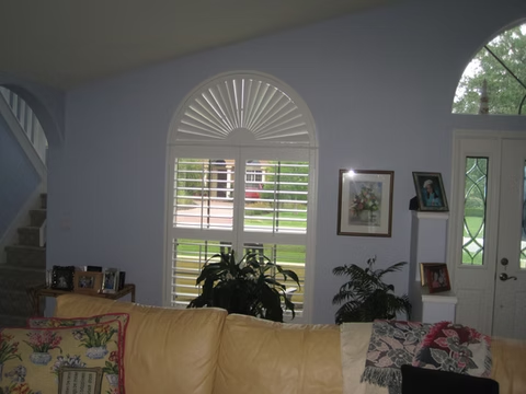 Sunburst and rectangular plantation shutters in a Ponte Vedra living room
